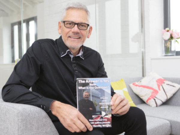 Neville with his book sitting in office
