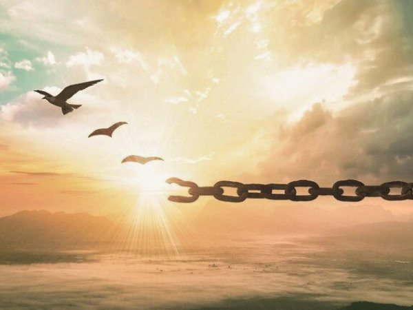 Doves flying away from broken chain