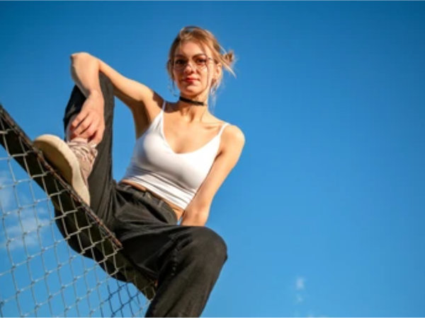 Girl Sitting on chain linked fence
